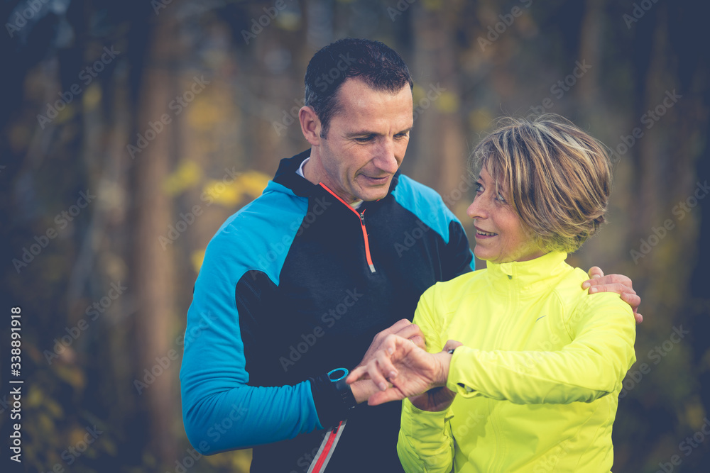 Paar beim Sport prüft Fitnessdaten Paar beim Sport prüft Fitnessdaten