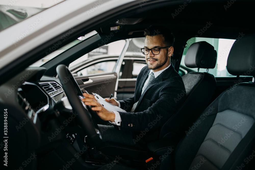 Car seller working in showroom and quality control checking of car details for the last time before buyer comes. Car seller working in showroom and quality control checking of car details for the last time before buyer comes.