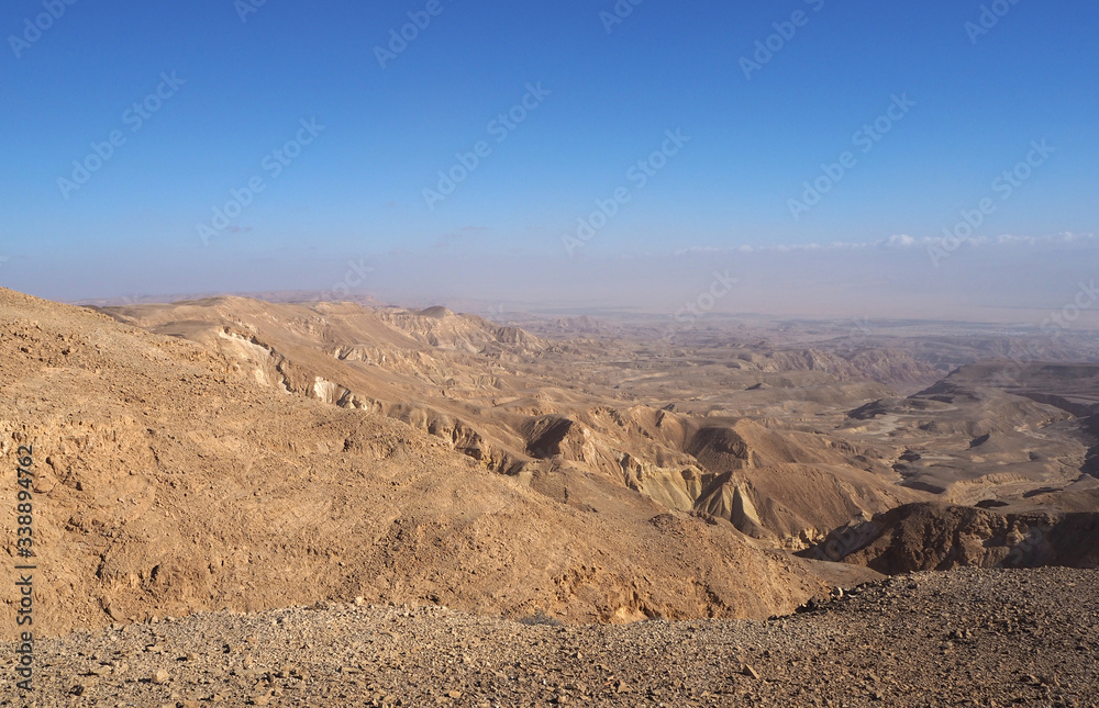The desert landscape with many yellow sandstone mountains and the blue sky