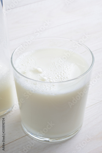 Vaso de leche y botella con tapón en la mesa blanca