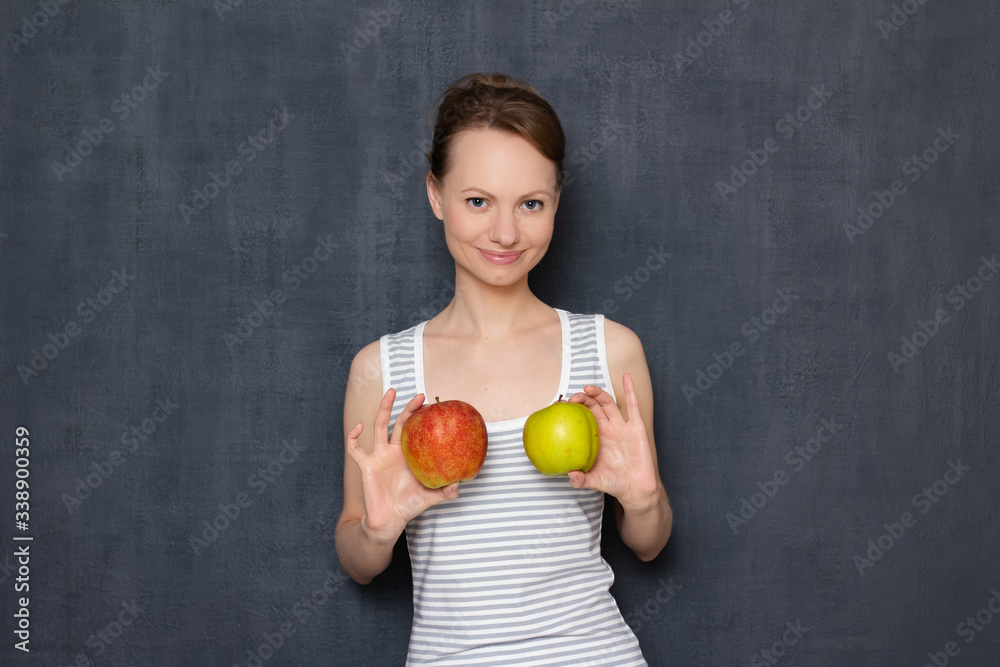 Portrait of cheerful young woman holding apples in hands over chest Portrait of cheerful young woman holding apples in hands over chest