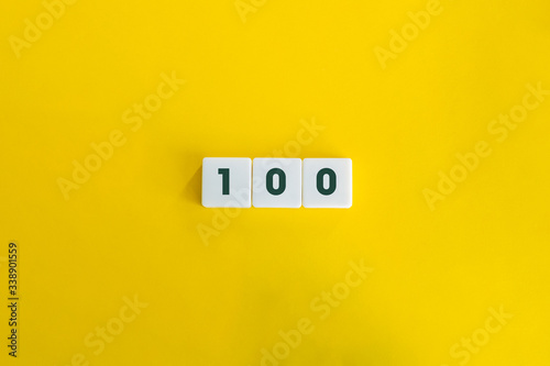Number hundred (100) on block letters, on the yellow  background. Minimal Aesthetics. photo