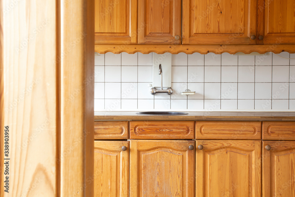 Full view of a classic wooden and kitchen with white tiled wall, retro vintage design complete furniture. close-up