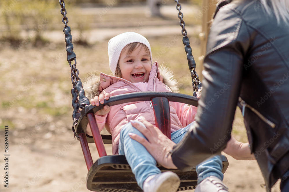 Little girl walks on the playground in the street
