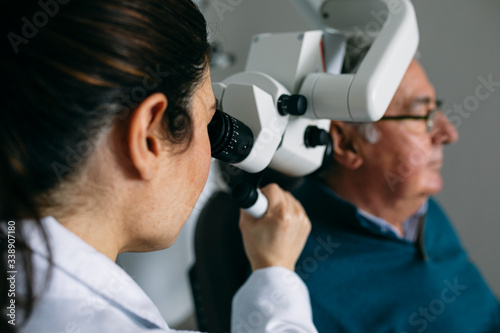 ENT physician examining ear of a senior man photo