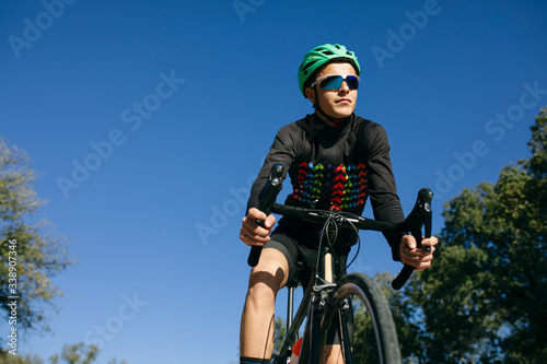 Athlete riding bicycle under blue sky