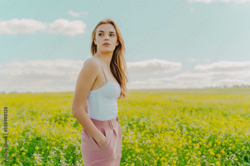 Young woman standing in a flower meadow in spring Young woman standing in a flower meadow in spring