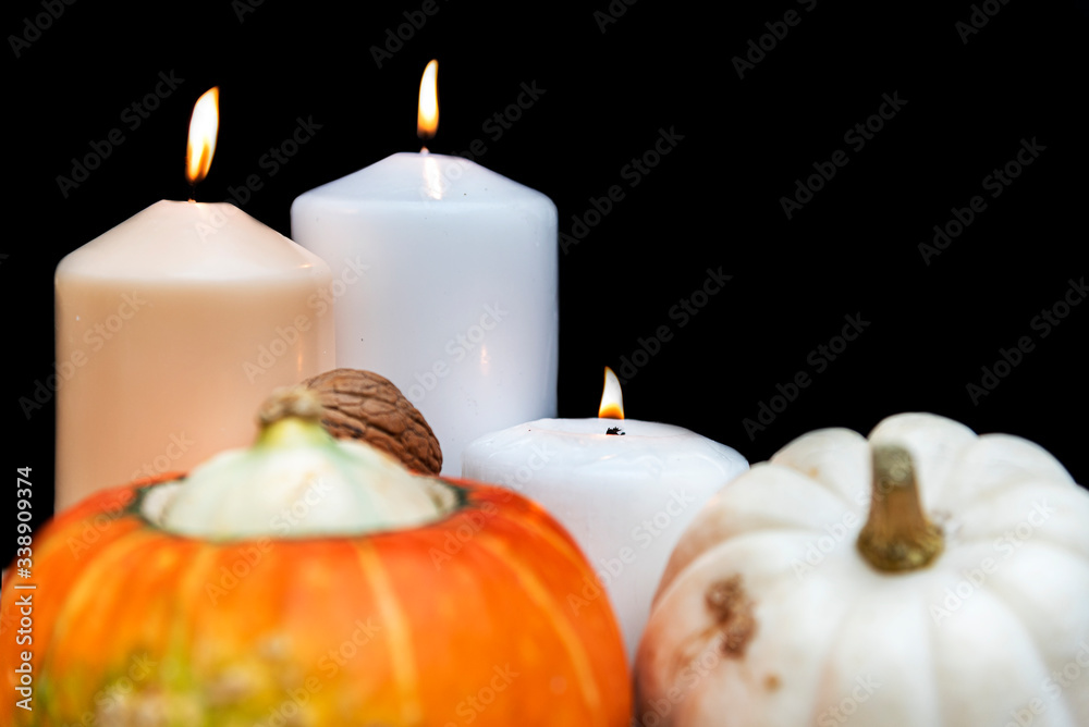 Two organic and healthy pumpkins, three candles and some walnuts on rustic background with copy space. Two organic and healthy pumpkins, three candles and some walnuts on rustic background with copy space.