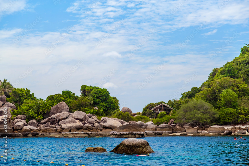 Koh Tao, Thailand - August 01, 2019 - The sea, houses in the greenery on the mountain, snorkeling