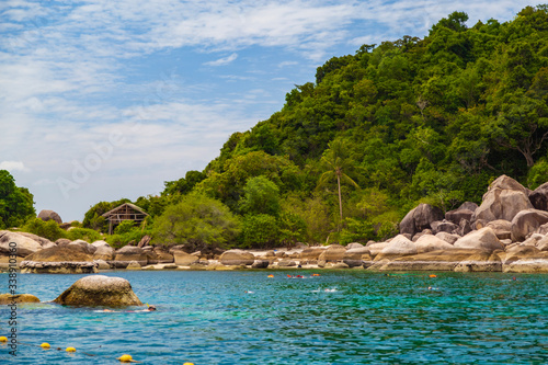 Koh Tao, Thailand - August 01, 2019 - The sea, houses in the greenery on the mountain, snorkeling