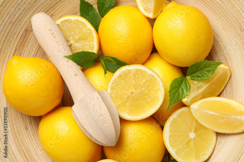 Bowl with lemons and juicer  top view. Ripe fruit