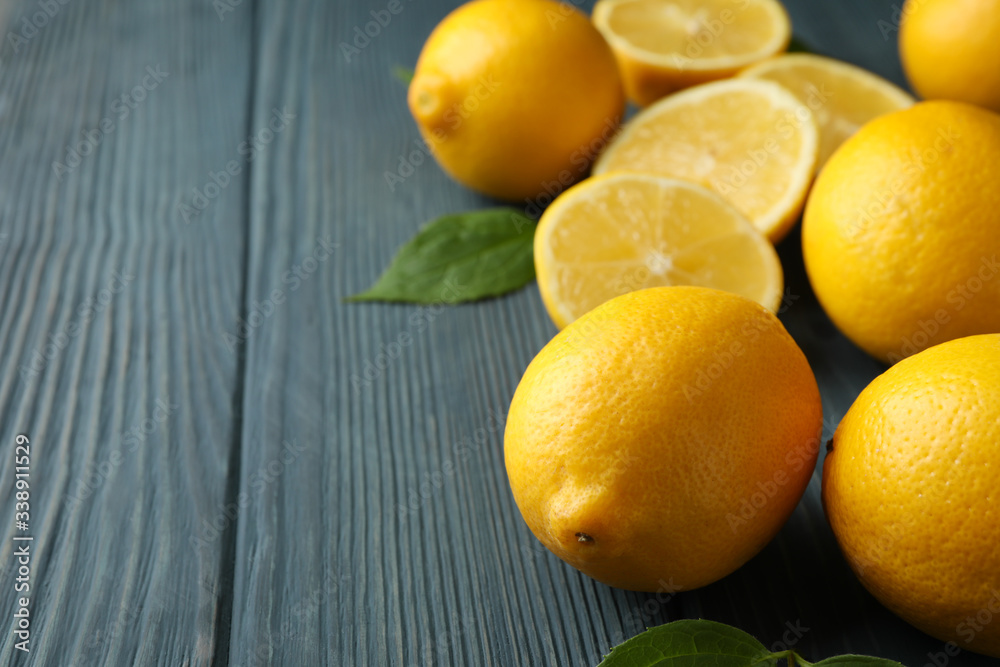 Fresh lemons and leaves on wooden background. Ripe fruit