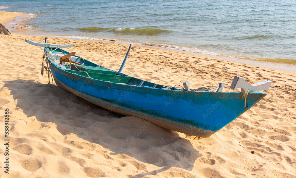 Abandoned fishing boat on the sandy seashore. Old wooden boat on tropical beach. Abandoned fishing boat on the sandy seashore. Old wooden boat on tropical beach.