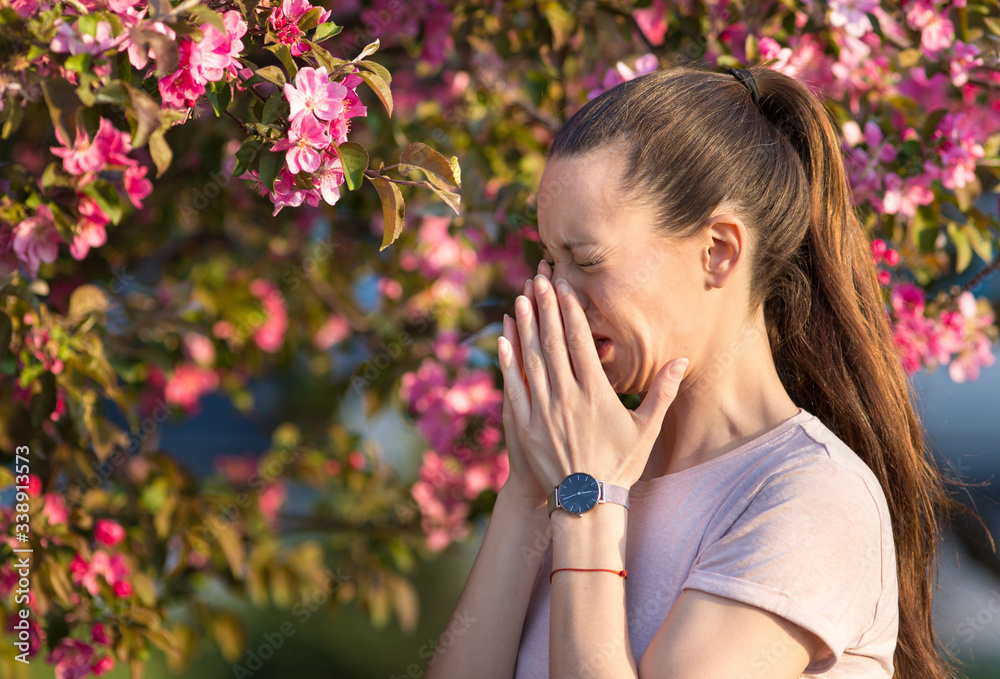 Woman sneezing because of spring pollen allergy Woman sneezing because of spring pollen allergy