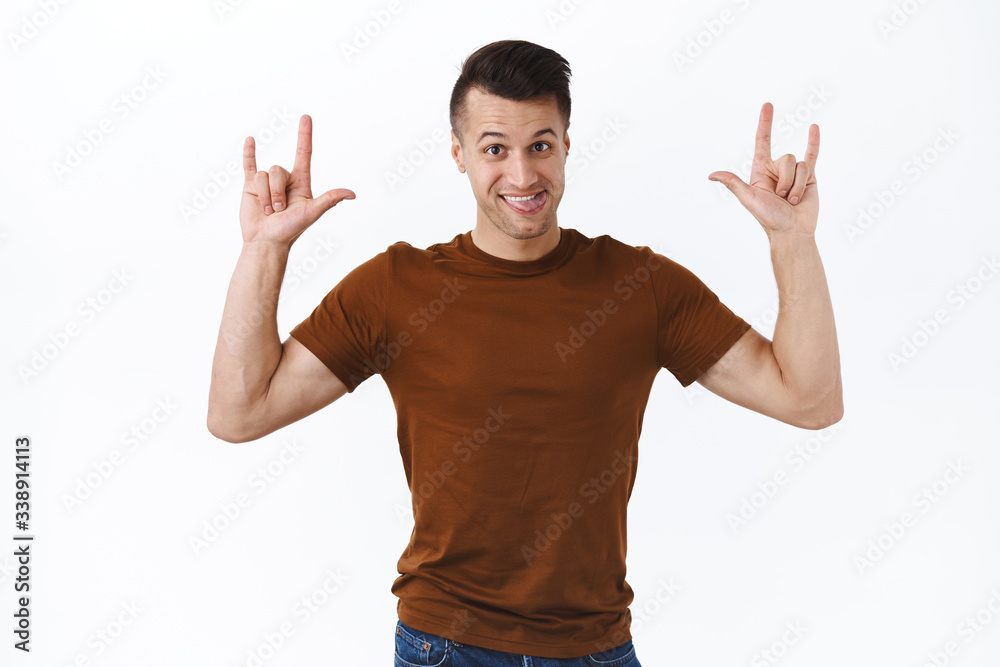 Rock on, portrait of cheerful happy caucasian man enjoying awesome festival or concert, praying, show tongue smiling and make heavy-metal signs, standing white background having fun Rock on, portrait of cheerful happy caucasian man enjoying awesome festival or concert, praying, show tongue smiling and make heavy-metal signs, standing white background having fun
