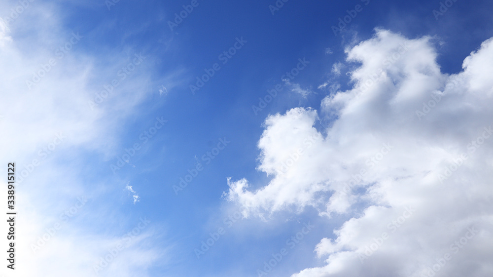 Background of blue sky with clouds. Blue, white pastel paradise, soft focus lenses, glare of sunlight. Abstract blurred blue gradient of a peaceful nature. , banner