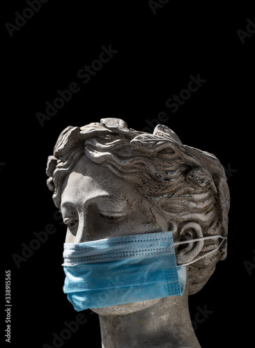 Italian statue in a protective mask with a sad look