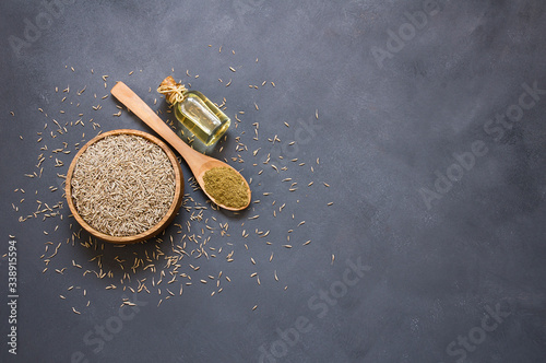 Bilde på lerret Glass bottle of Caraway seeds essential oil with caraway powder in wooden spoon