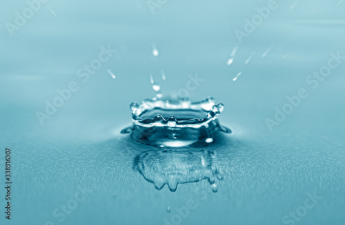 Close-up macro picture of drop on water surface, water drops splash as background