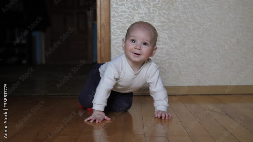 Funny Cheerful Caucasian Baby Learns To Crawl On All Fours On The Floor In House Funny Cheerful Caucasian Baby Learns To Crawl On All Fours On The Floor In House