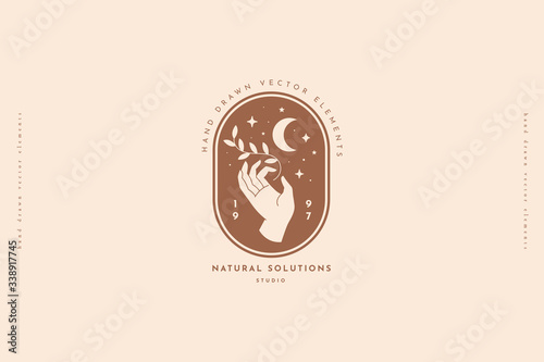 Hand keeps branch with sheets, crescent, stars. Minimal style logo design template. Trendy magic symbol on a light background. Emblem for organic cosmetics and packaging for handmade products.