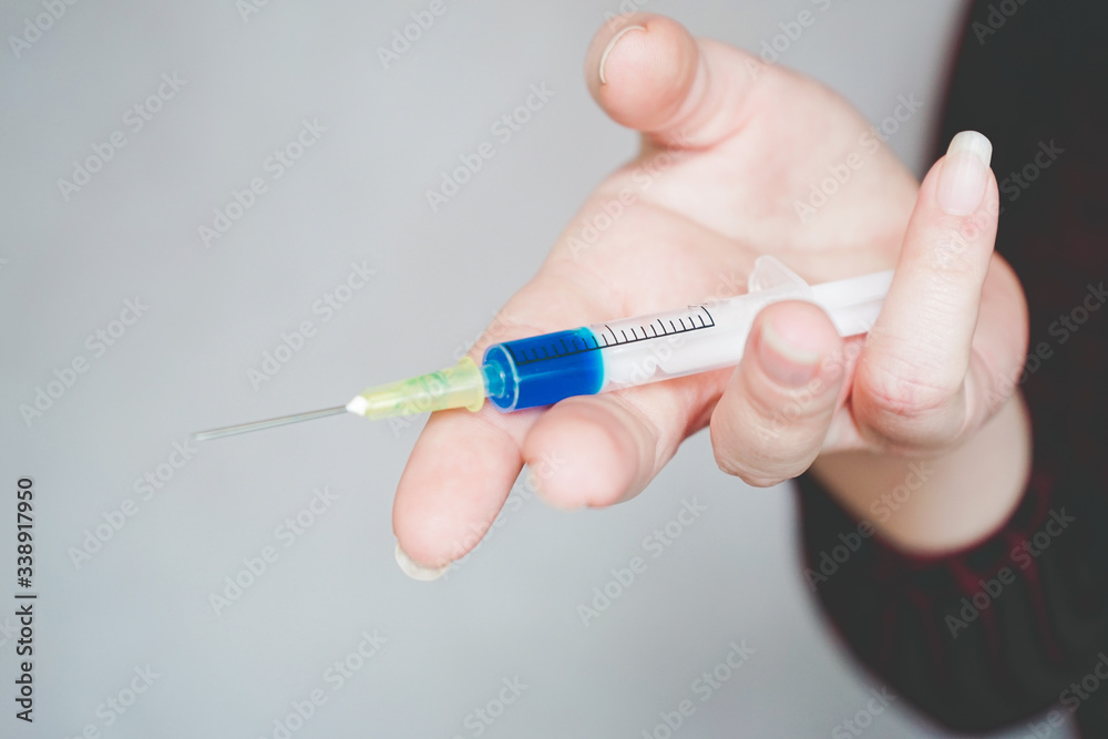 Human hand holding a syringe Human hand holding a syringe