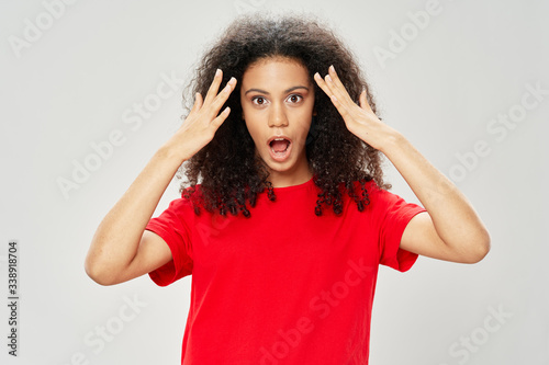 Cheerful emotional woman curly hair red t-shirt studio tin with hands