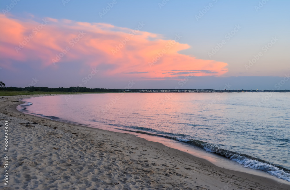 Pink sunset view from point at Cape Henlopen State Park looking toward town in distance
