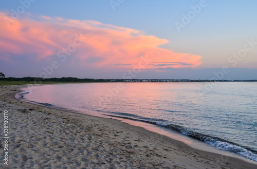 Pink sunset view from point at Cape Henlopen State Park looking toward town in distance photo