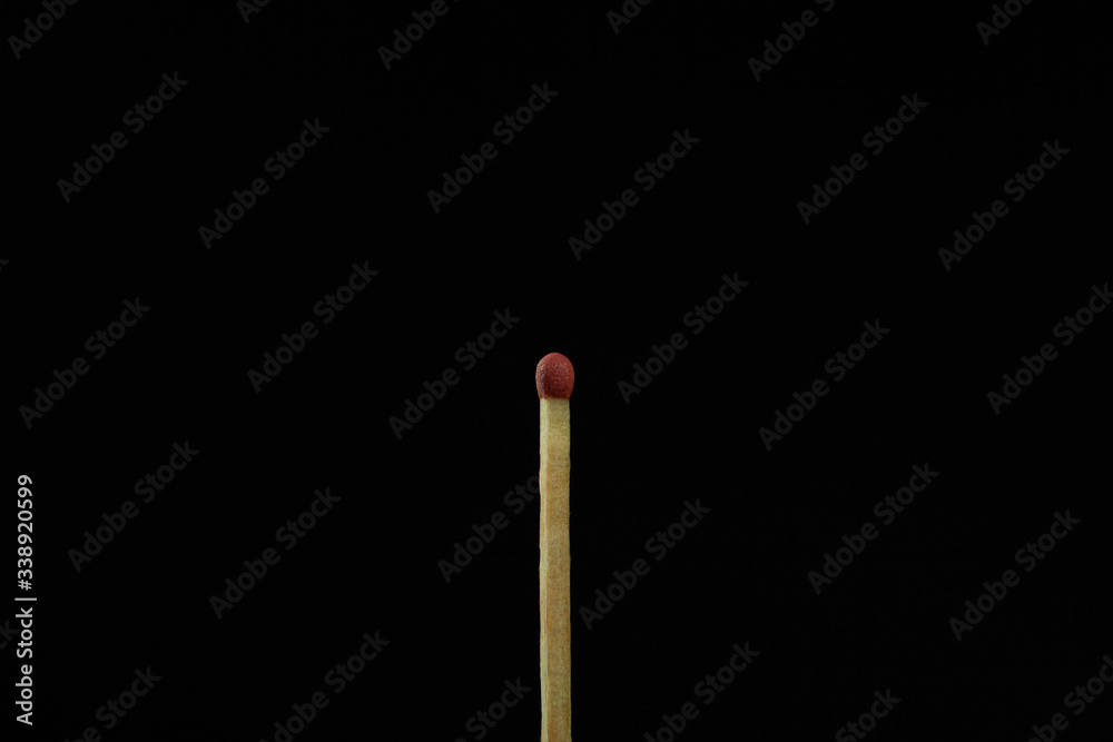 One match on the black background isolated side view One match on the black background isolated side view