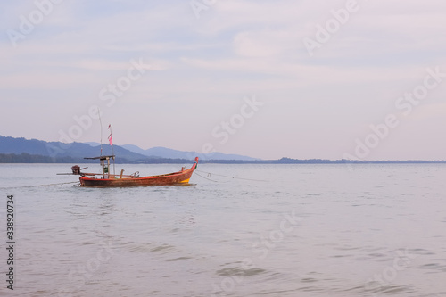 longtail boat standing near the shore at sunset.Beautiful sunset of fishing village in Phang Nga Bay with longtail wooden fishing boat ,Thailand.Travel by Asia. Landscape with traditional fishing boat