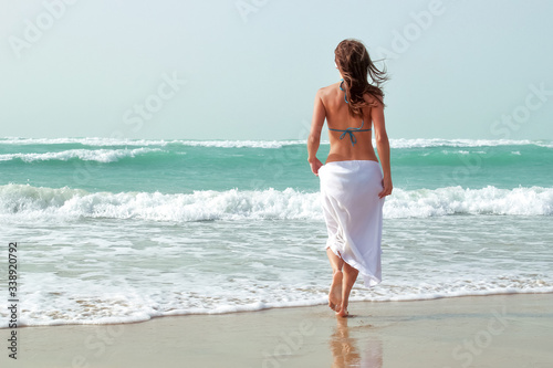 Beautiful girl walks along the ocean.   oncept of rest.
