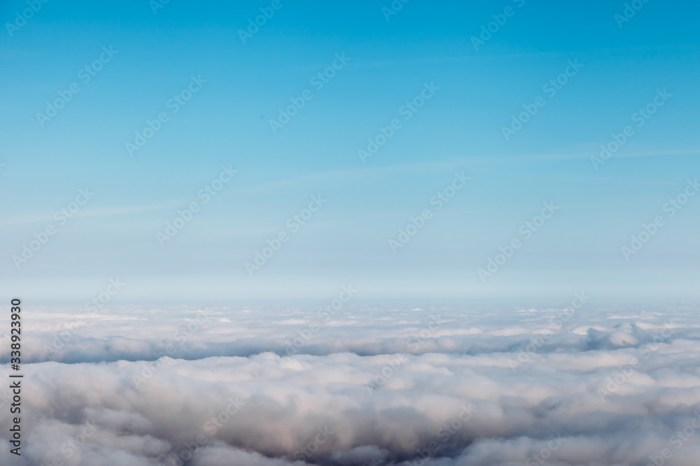 bird eye view at clouds in blue sky top view from drone from airplane window
