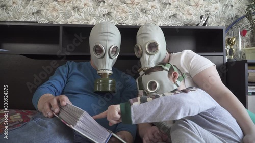 Family in gas masks from viruses watch photo album