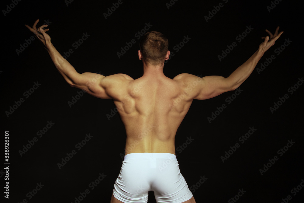 Strong stripped muscle male model in white underwear on black isolated font background Strong stripped muscle male model in white underwear on black isolated font background