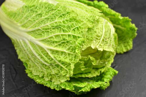 Chinese cabbage on black background. Vegan eco-conscious food concept.