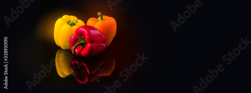yellow, red and orange pepper paprika on a black background