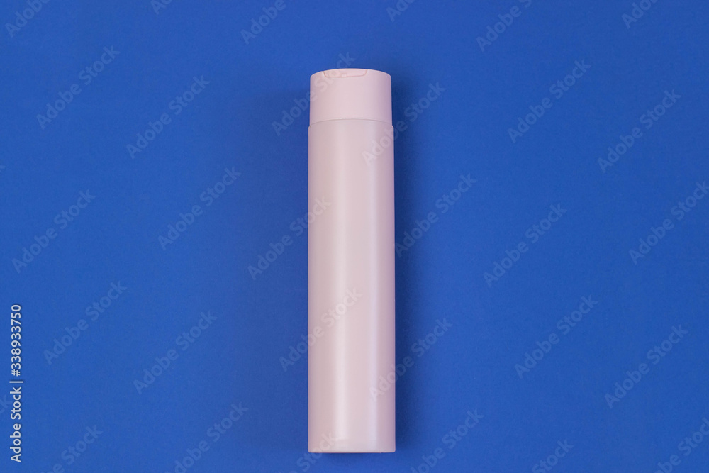 Cosmetic pink bottle with serum, gel, face cream on a blue background. Skin cosmetics, minimalism. The concept of salon procedures. Cosmetic pink bottle with serum, gel, face cream on a blue background. Skin cosmetics, minimalism. The concept of salon procedures.
