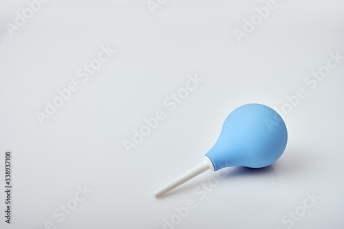 Blue syringe with white plastic nozzle on white acrylic table