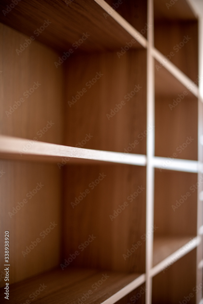 A sideway look along empty wooden bookshelf A sideway look along empty wooden bookshelf