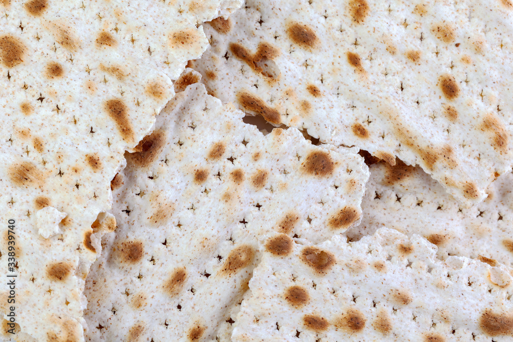 Matzo. Traditional jewish easter bread. Passover holiday symbol. Matzah broken, lies in a heap. With some free space for your text or sign. Close-up.