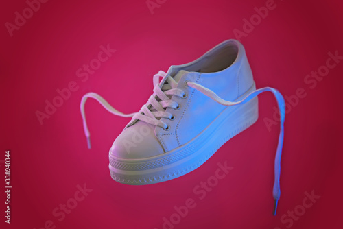 Flying in the air white sneaker. Abstract surrealism and minimalism shopping concept.