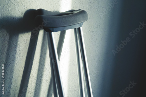 Close up image of crutches are standing against the wall. Place for text.