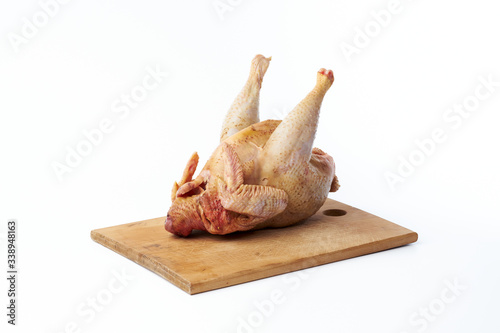 Fresh raw chicken on a cutting board isolated on a white background.