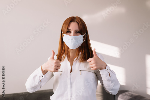 Happy adult woman wearing protective mask, isolated on grey background.coronavirus pandemic - covid-19. Medical mask advertising photo