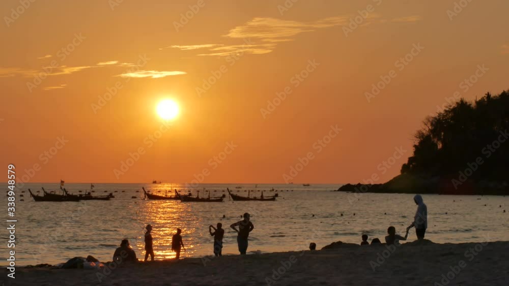 sunset over ocean, long tail fishing boat mooring in sea,wave water hit shore,silhouette people on sandy beach,silhouette tree branch mountain cape, golden cloudy twilight background evening time sunset over ocean, long tail fishing boat mooring in sea,wave water hit shore,silhouette people on sandy beach,silhouette tree branch mountain cape, golden cloudy twilight background evening time