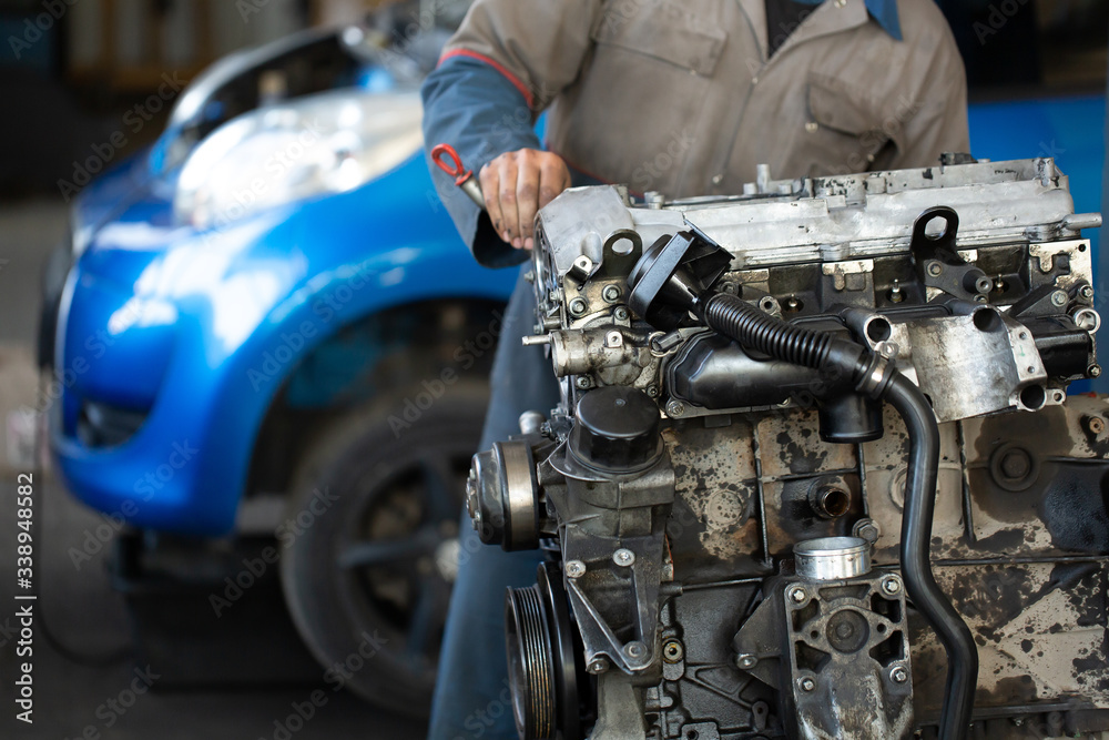 Master, car mechanic repairs the car engine at the service station Master, car mechanic repairs the car engine at the service station
