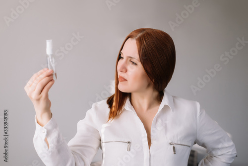 Woman looking at the sanitizes gel at home. Woman uses an antibacterial hand cleaner.