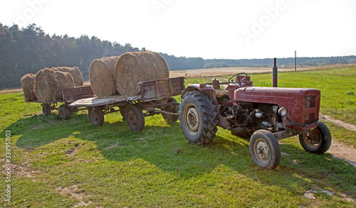 Round hay bales loaded on farmer's wagons ready to be transported by tractor to the barn for storage. Zawady Gmina Rzeczyca Poland