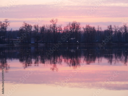 Lake at sunset, on a background of trees. Reflection of nature in the lake. Diamond Lake Kiev, Ukraine.